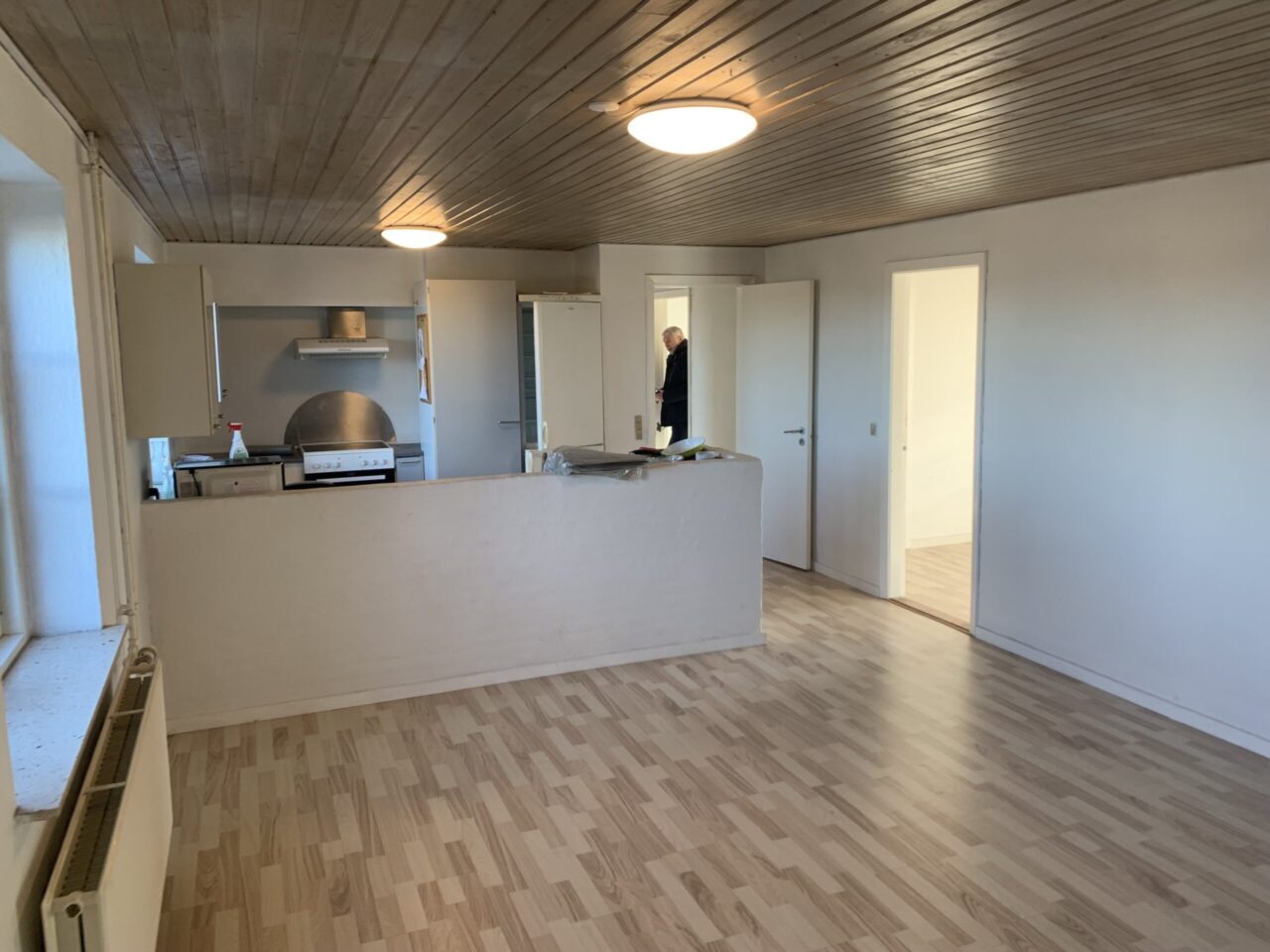 Investeringsejendom i Christiansfeld - Køkken og stue som har hvide vægge og trægulv