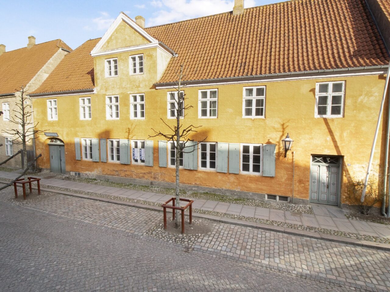 Lokaler til Leje i Christiansfeld -Orange facade med hvide vinduer og røde tagsten