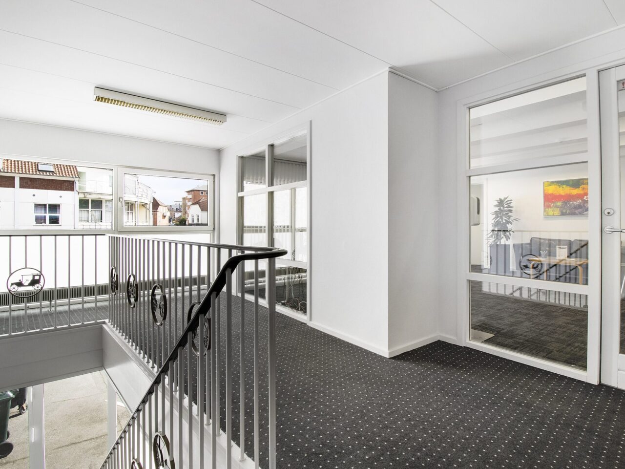 Lokaler til leje i Kolding Centrum - Indgang med trappe, hvide vægge og loft, grå gulvtæppe og vinduer