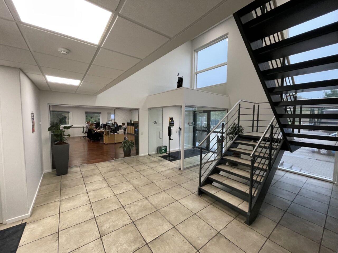 Kontor til leje i Kolding - Indgange med en trappe med beige fliser og sort gelænder og hvide vægge