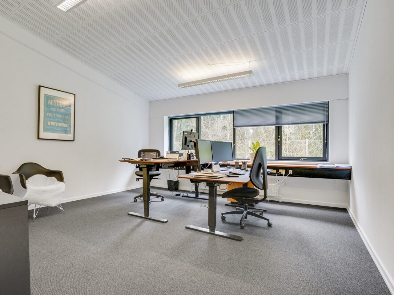 lager og kontorlejemål i Vejen - lokale med hvide vægge og grå gulv, med stor vinduer og to skrivebord